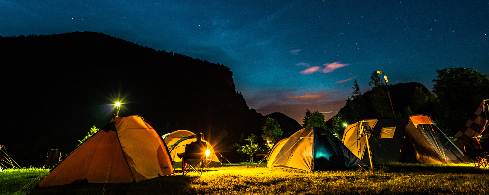 Beleuchtete Zelte unter dem Sternenhimmel der Nacht