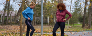 Zwei Frauen in Sportkleidung trainieren gemeinsam im Park
